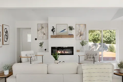 a living room with furniture a fireplace and a large window