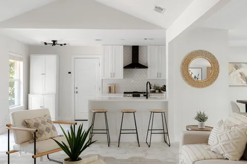 a living room with furniture a mirror and a potted plant