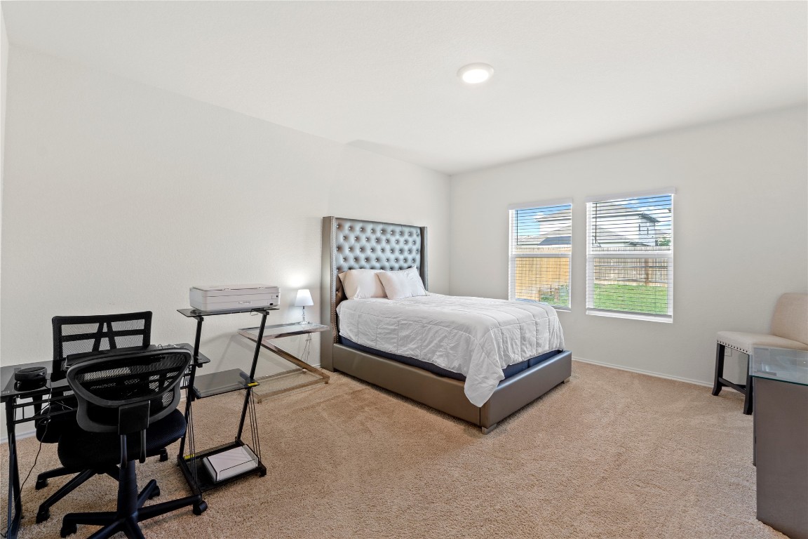 14806 Bajada Road Manor, TX 78653 - Photo 14 of 28 a bedroom with a bed a chair and a large window