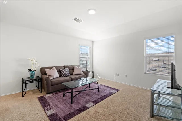 a living room with furniture a rug and a window