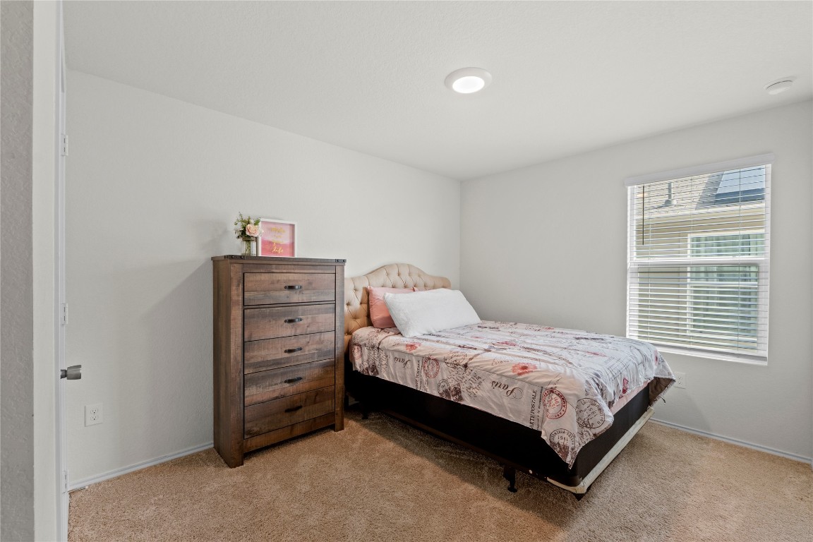 14806 Bajada Road Manor, TX 78653 - Photo 22 of 28 a bedroom with a bed and a window
