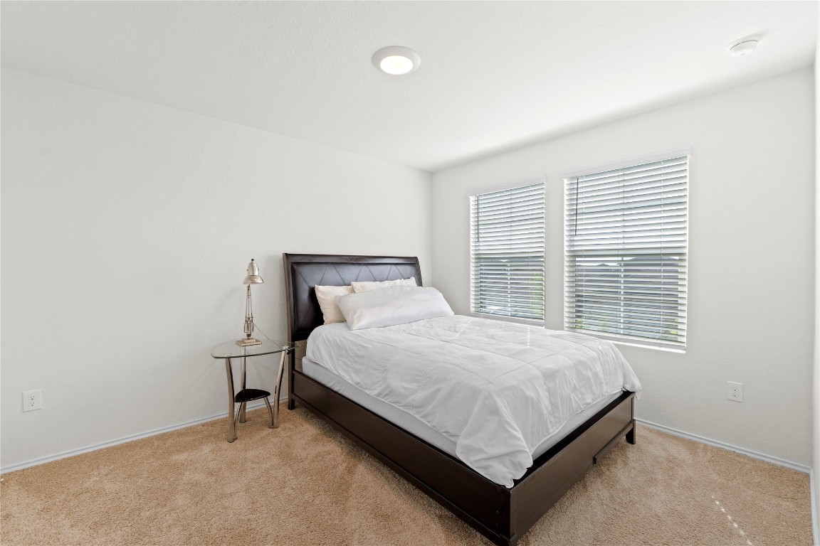 14806 Bajada Road Manor, TX 78653 - Photo 23 of 28 a bed sitting in a bedroom next to a window