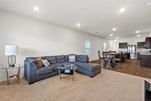 a living room with furniture and kitchen view