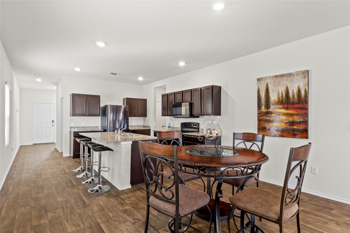 14806 Bajada Road Manor, TX 78653 - Photo 8 of 28 a view of a dining room with furniture and wooden floor