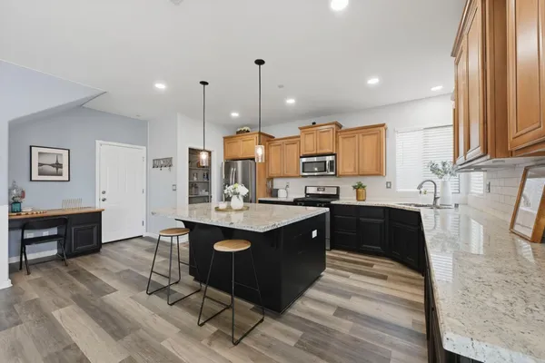 a kitchen with stainless steel appliances granite countertop a sink a stove top oven a counter space and cabinets