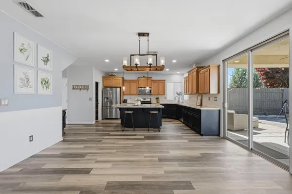 a kitchen with kitchen island a counter top space stainless steel appliances and a large window