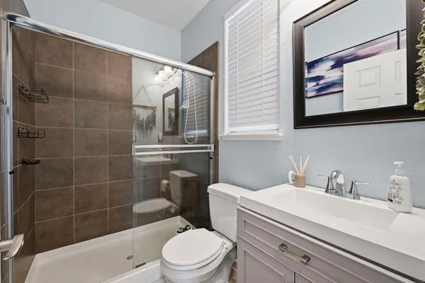 a bathroom with a sink a toilet and shower