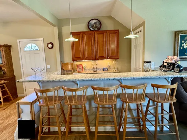 a view of a kitchen with granite countertop a sink a stove a oven a counter space and cabinets