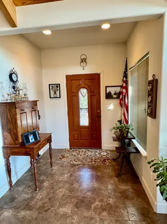 a kitchen with stainless steel appliances granite countertop a dining table chairs refrigerator sink and cabinets