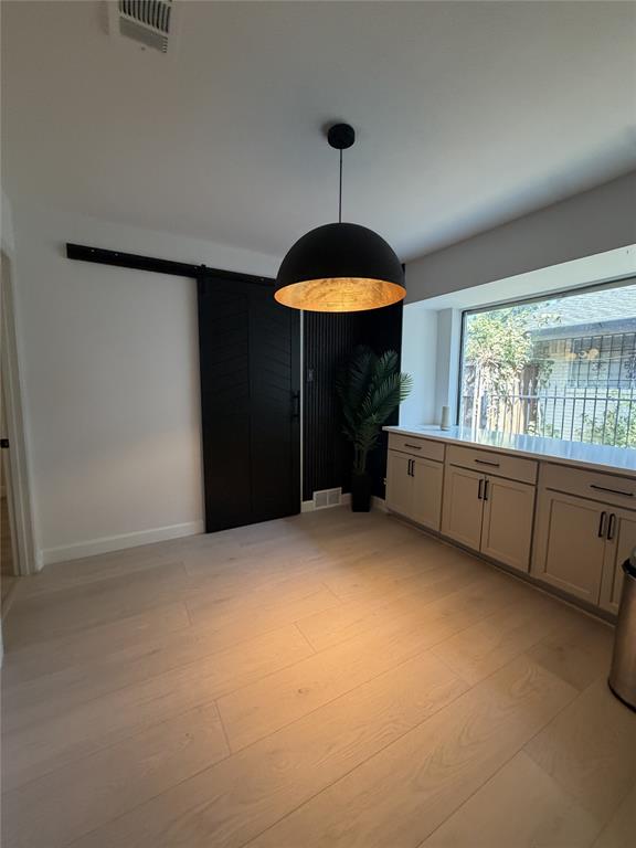 5021 Ashbrook Road Dallas, TX 75227 - Photo 8 of 12 Light wood-finish flooring with a modern pendant light