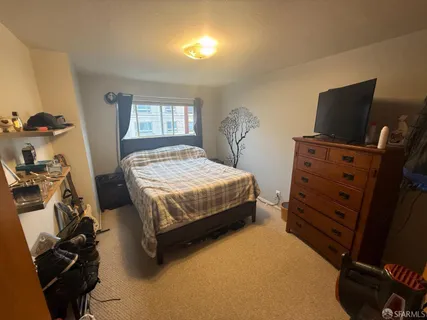 a bedroom with a bed and a tv on the dresser