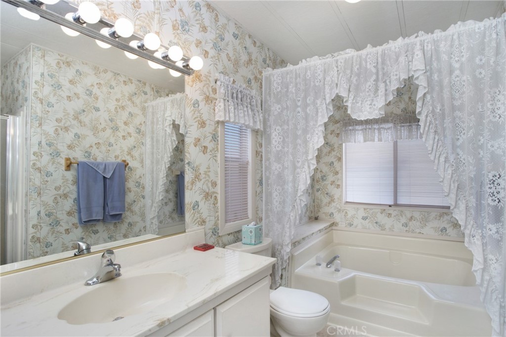 692 North Adele Street, Unit 49 Orange, CA 92867 - Photo 10 of 16 a bathroom with a bathtub sink vanity mirror and toilet