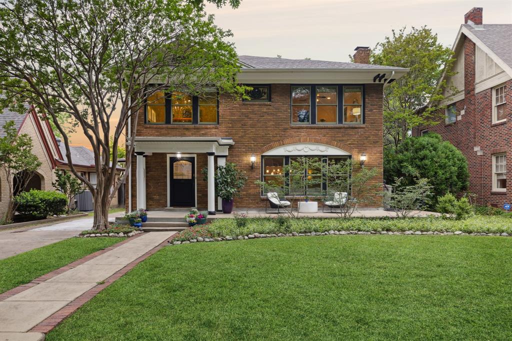 front view of a brick house with a yard