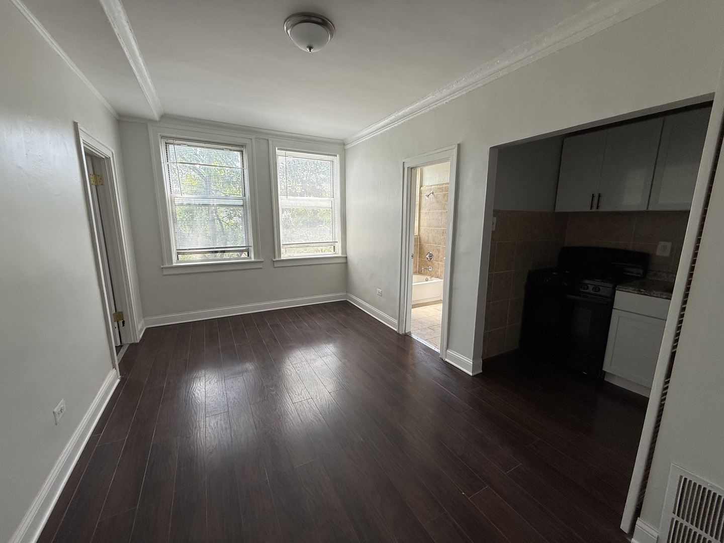 3420 West Irving Park Road, Unit 24 Chicago, IL 60618 - Photo 2 of 6 an empty room with wooden floor and windows