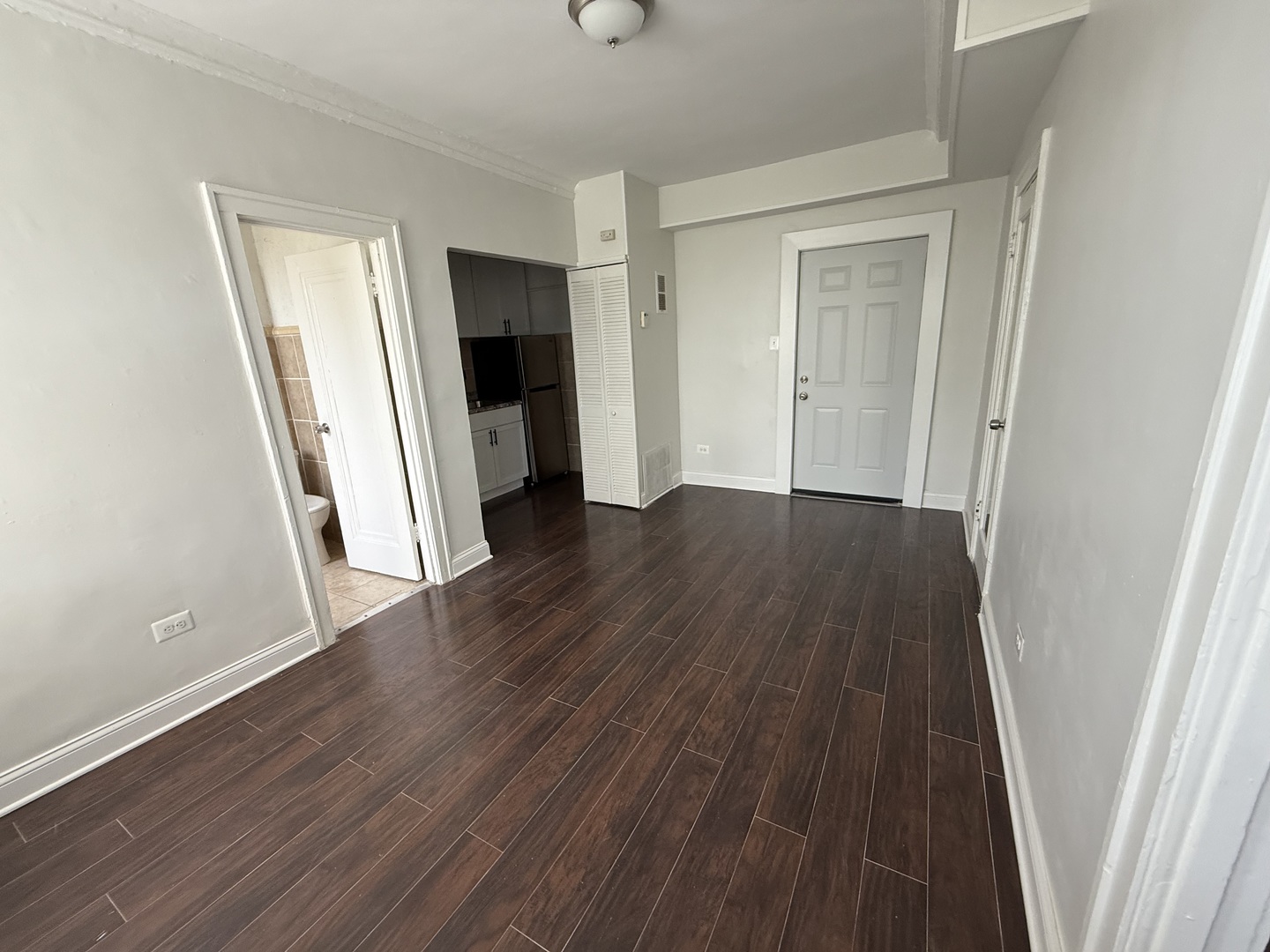 3420 West Irving Park Road, Unit 24 Chicago, IL 60618 - Photo 3 of 6 an empty room with wooden floor and a window