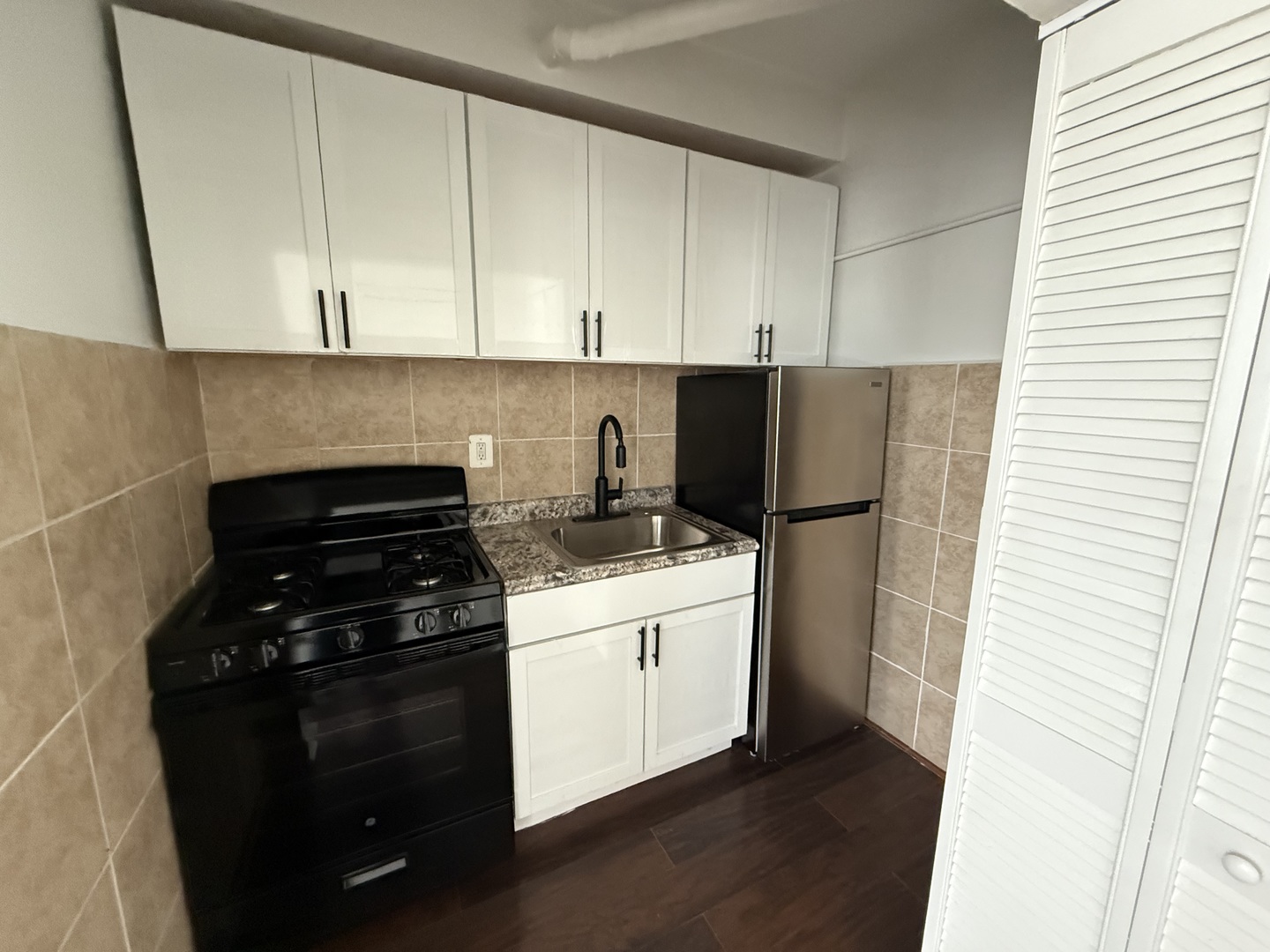 3420 West Irving Park Road, Unit 24 Chicago, IL 60618 - Photo 4 of 6 a kitchen with a refrigerator stove and cabinets