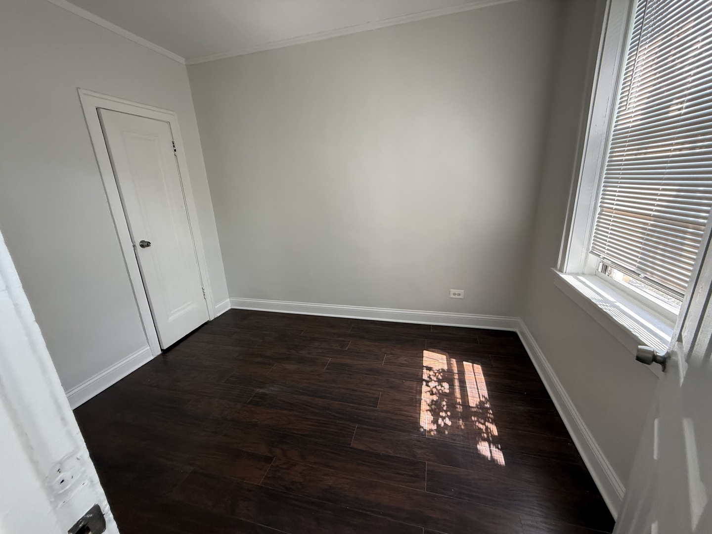 3420 West Irving Park Road, Unit 24 Chicago, IL 60618 - Photo 5 of 6 wooden floor in an empty room with a window