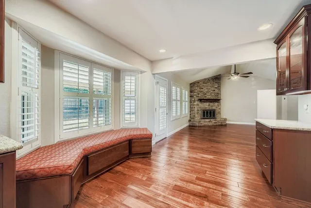 a large kitchen with a large counter top space a sink stainless steel appliances and cabinets