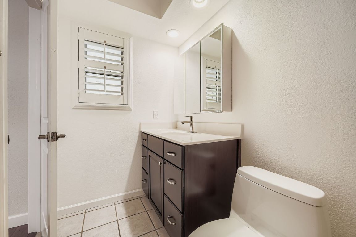 7202 Beckett Road Austin, TX 78749 - Photo 17 of 28 a bathroom with a toilet sink and mirror