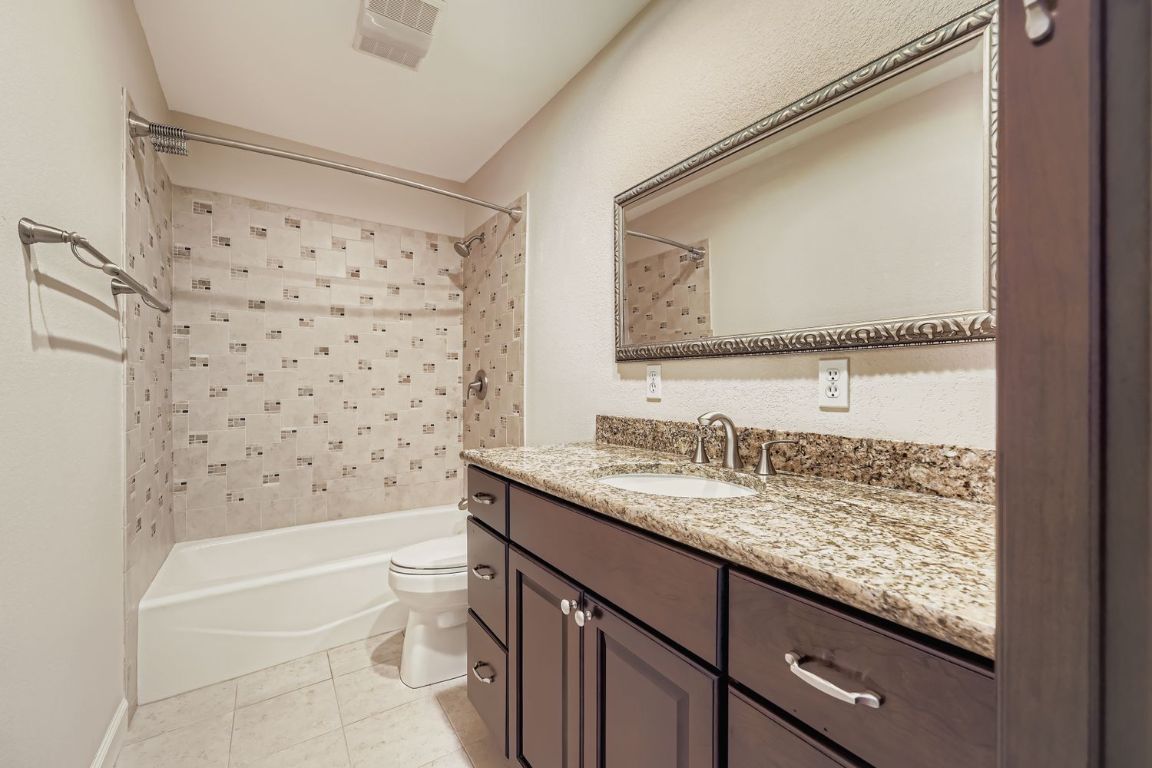 7202 Beckett Road Austin, TX 78749 - Photo 20 of 28 a bathroom with a granite countertop sink toilet and shower