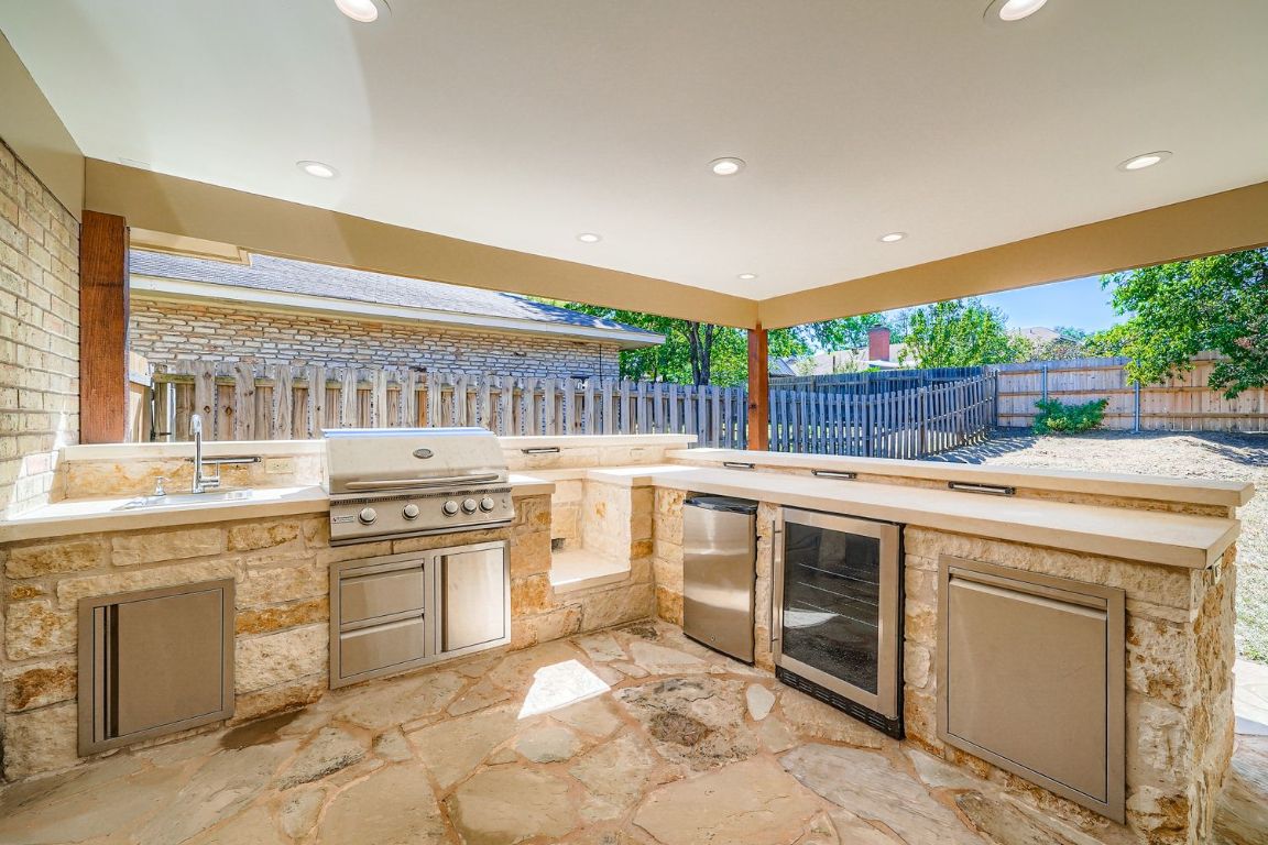 7202 Beckett Road Austin, TX 78749 - Photo 23 of 28 a kitchen with stainless steel appliances granite countertop a stove and white cabinets