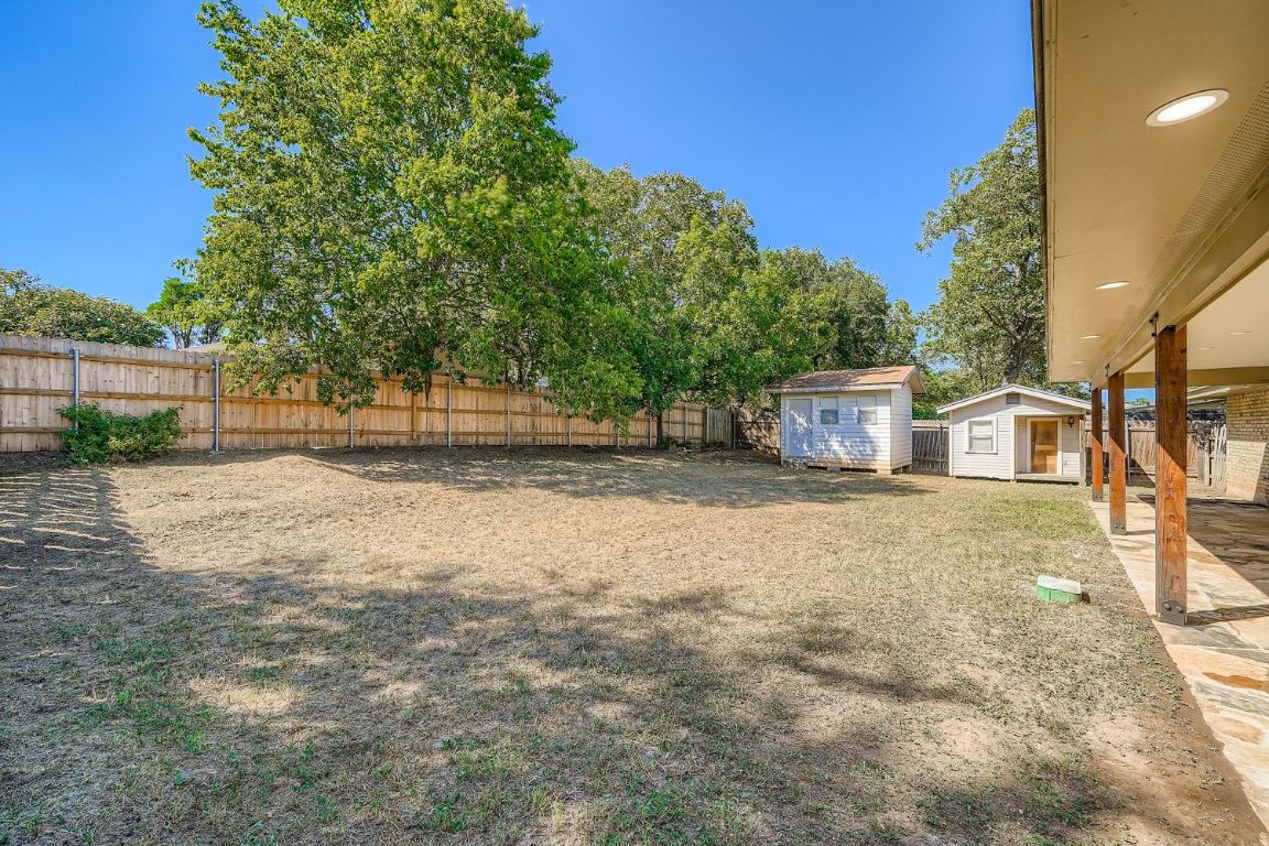 7202 Beckett Road Austin, TX 78749 - Photo 25 of 28 a backyard of a house with large trees and outdoor seating