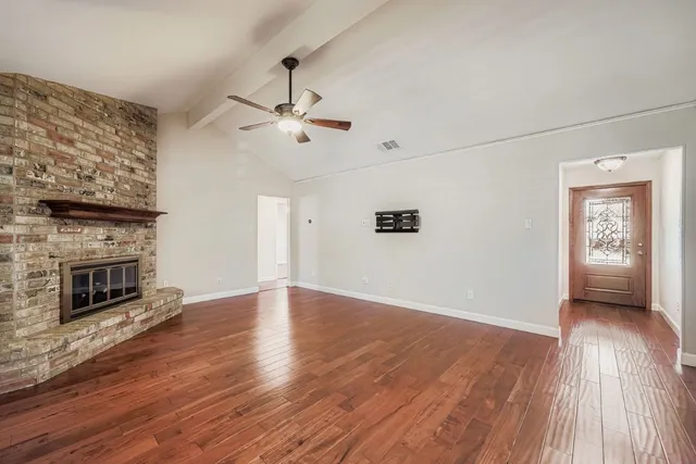 wooden floor in an empty room with a fireplace