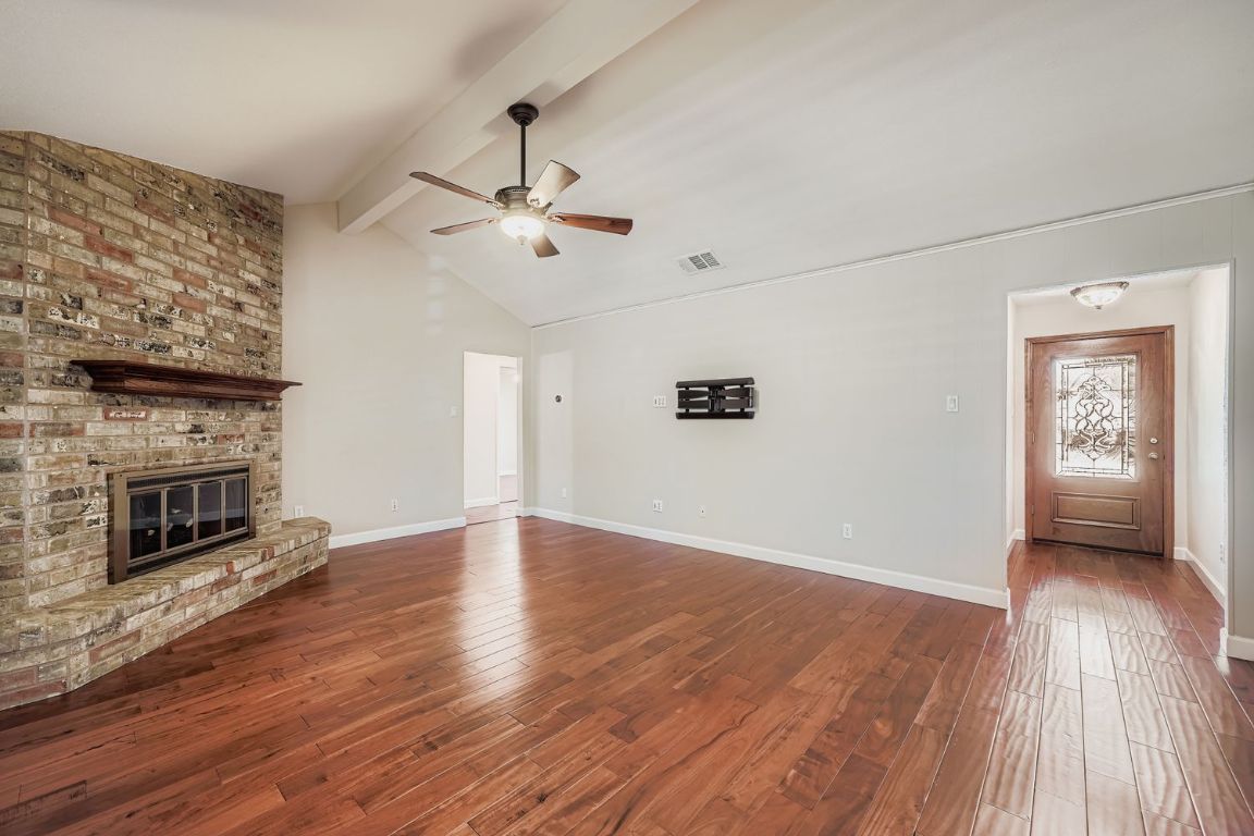 7202 Beckett Road Austin, TX 78749 - Photo 6 of 28 wooden floor in an empty room with a fireplace
