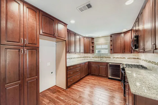 a kitchen with granite countertop wooden cabinets and white appliances