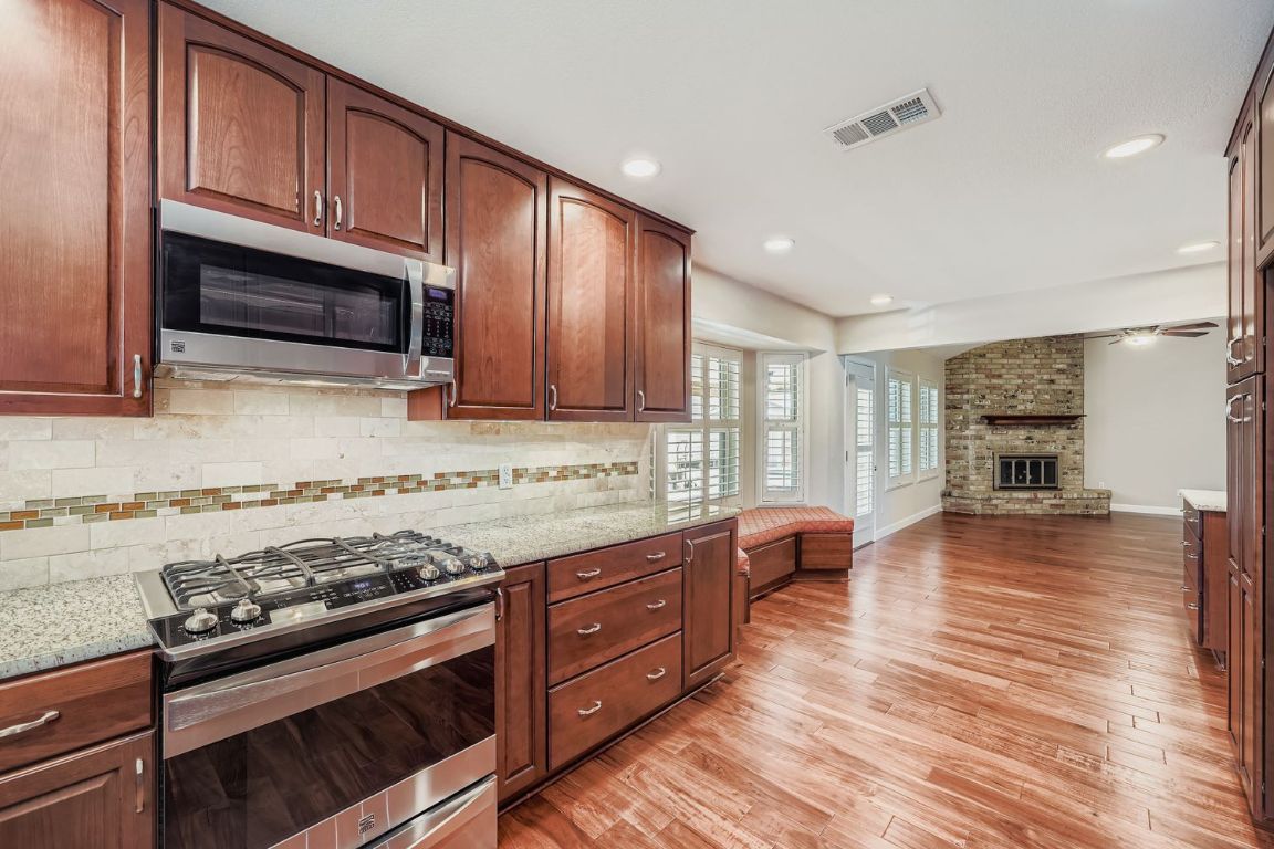 7202 Beckett Road Austin, TX 78749 - Photo 28 of 28 a kitchen with stainless steel appliances granite countertop a stove and a wooden floors