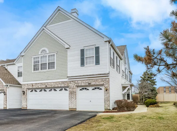 a view of a white house with a yard and garage