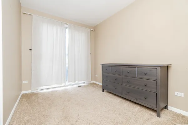 a view of an empty room with cabinet and mirror