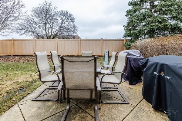 a view of a patio with table and chairs with wooden fence