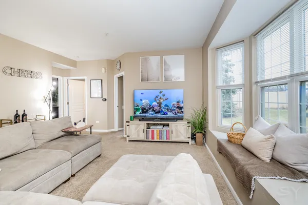 a living room with furniture large window and a chandelier