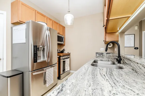 a kitchen with stainless steel appliances granite countertop a refrigerator and a sink