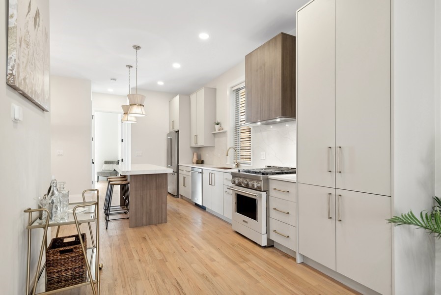 2139 West Crystal Street, Unit 1 Chicago, IL 60622 - Photo 6 of 27 a large kitchen with cabinets wooden floor and stainless steel appliances