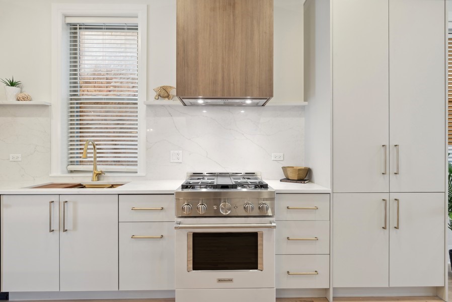 2139 West Crystal Street, Unit 1 Chicago, IL 60622 - Photo 7 of 27 a kitchen with granite countertop white cabinets and white stove