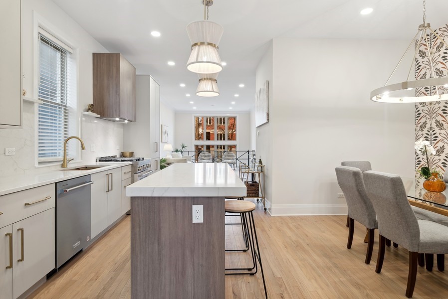 2139 West Crystal Street, Unit 1 Chicago, IL 60622 - Photo 10 of 27 a kitchen with stainless steel appliances granite countertop a kitchen island a stove a table and chairs in it