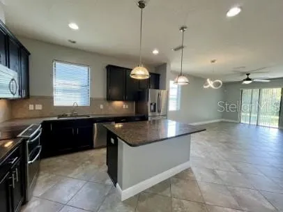 a kitchen with a stove a sink a counter space and a window