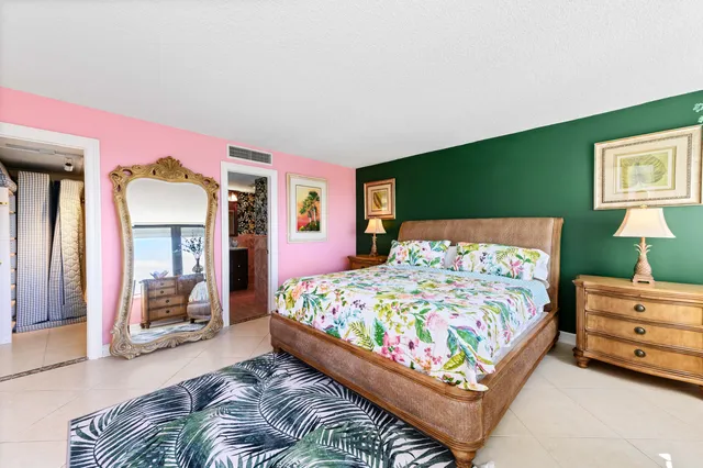 a bed sitting in a bedroom next to a window and a flat screen tv