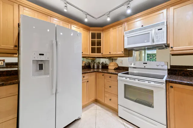 a kitchen with stainless steel appliances granite countertop a stove a sink and a refrigerator