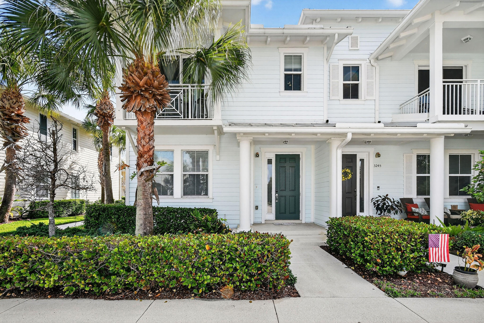front view of a white house with a small yard