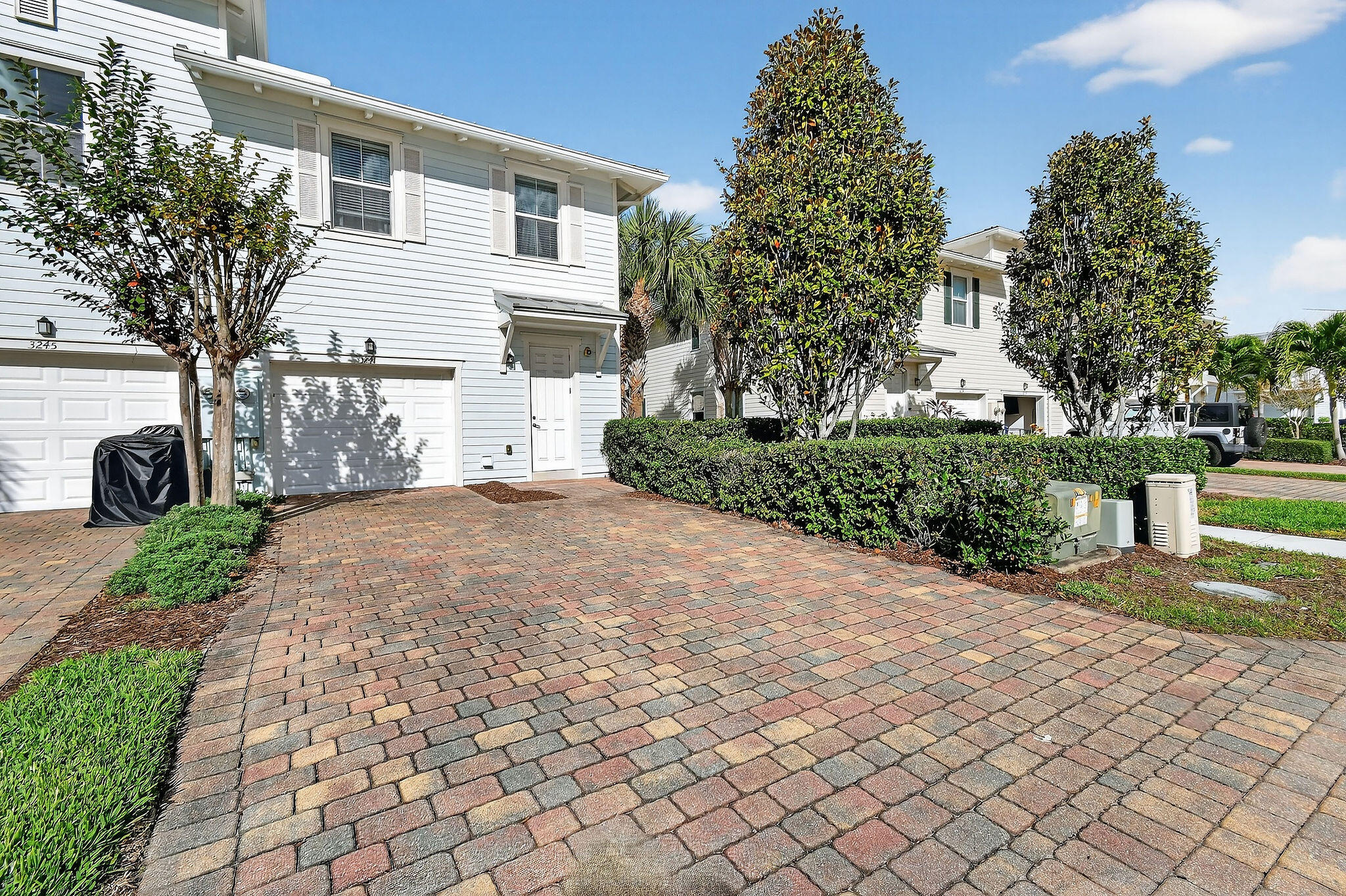 3241 Hemingway Drive Jupiter, FL 33458 - Photo 38 of 39 a front view of a house with a yard and a garage