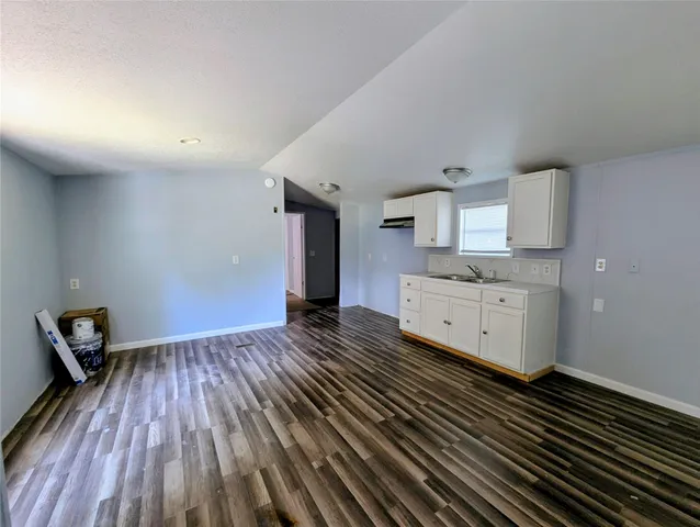 a room with a sink cabinets and wooden floor