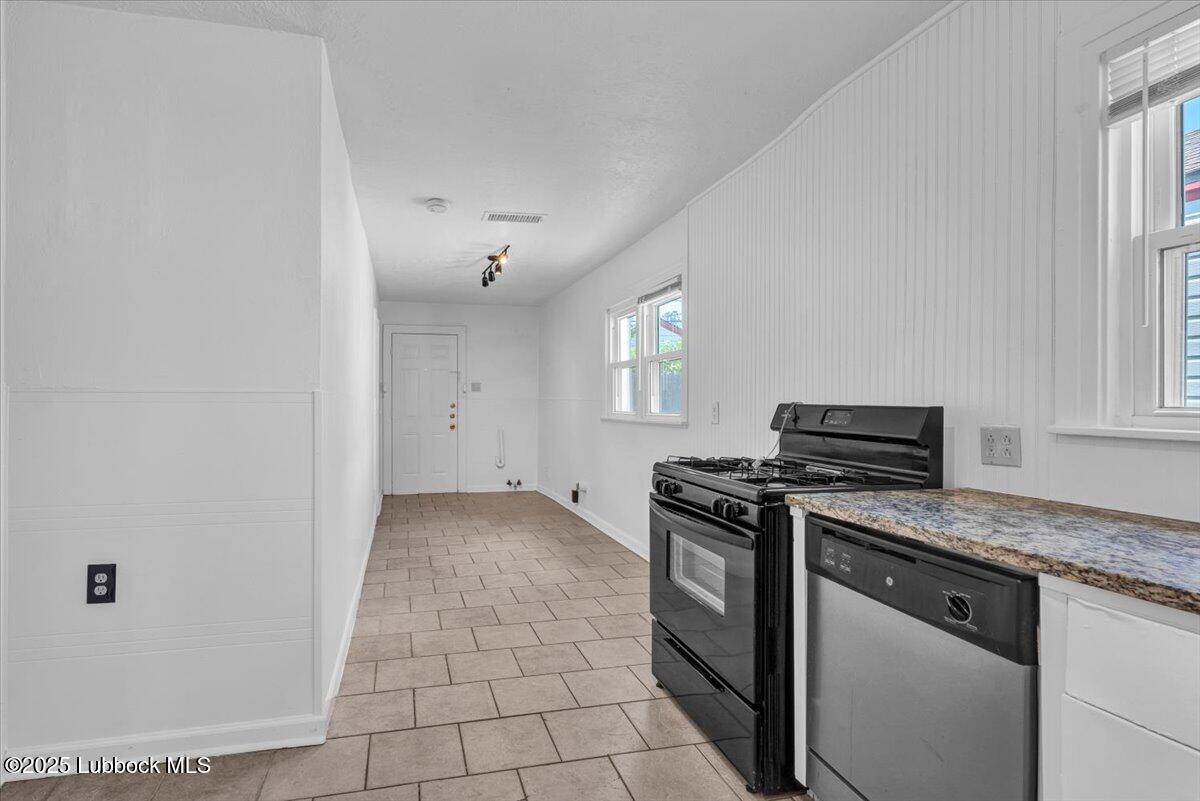 2427 26th Street Lubbock, TX 79411 - Photo 11 of 28 a kitchen with a stove top oven and cabinets