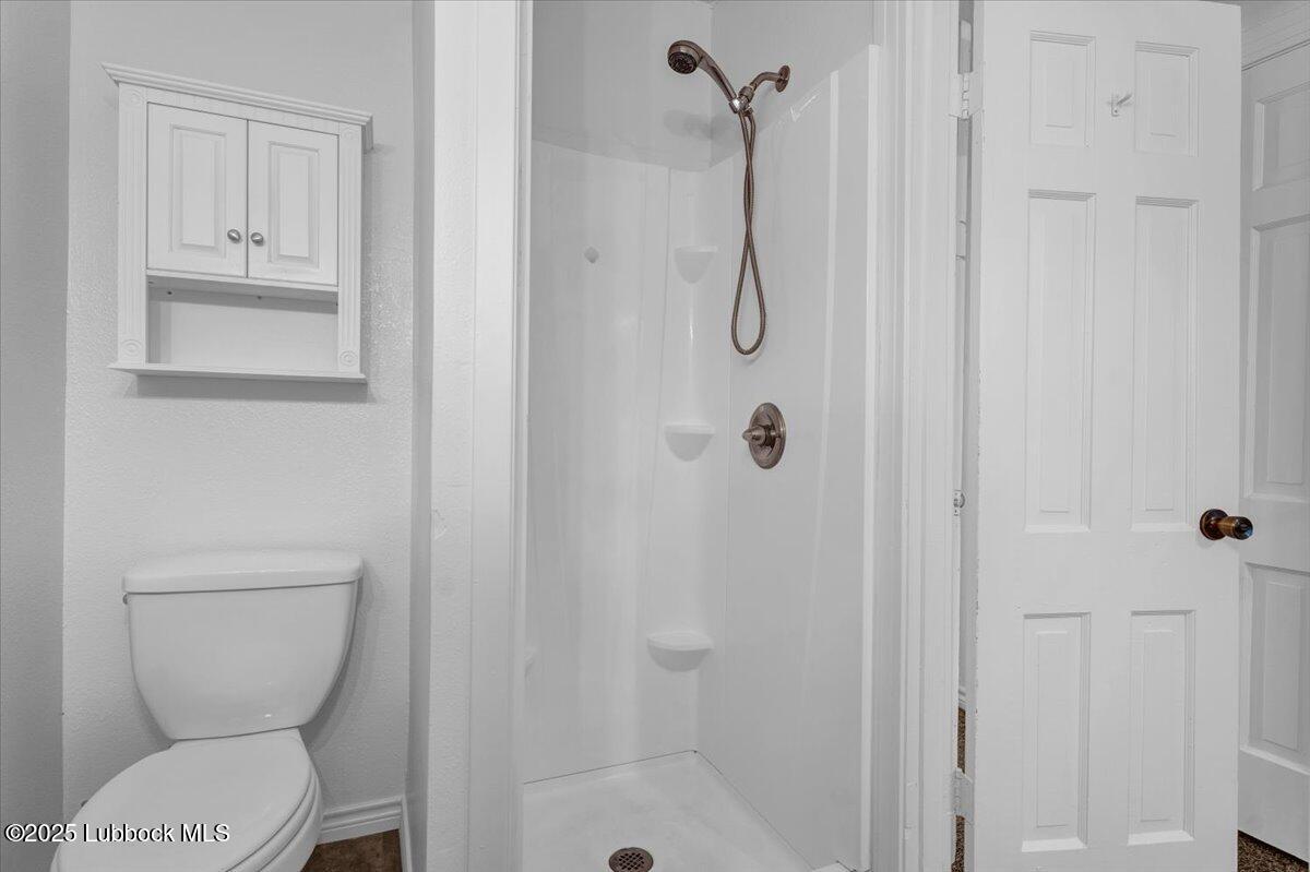 2427 26th Street Lubbock, TX 79411 - Photo 14 of 28 a bathroom with a toilet and shower