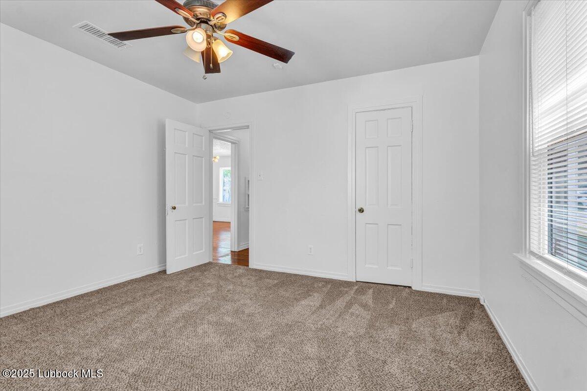2427 26th Street Lubbock, TX 79411 - Photo 18 of 28 a view of an empty room and window with a chandelier fan