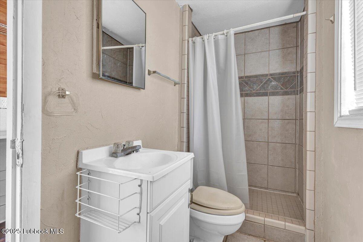 2427 26th Street Lubbock, TX 79411 - Photo 24 of 28 a bathroom with a sink toilet and shower