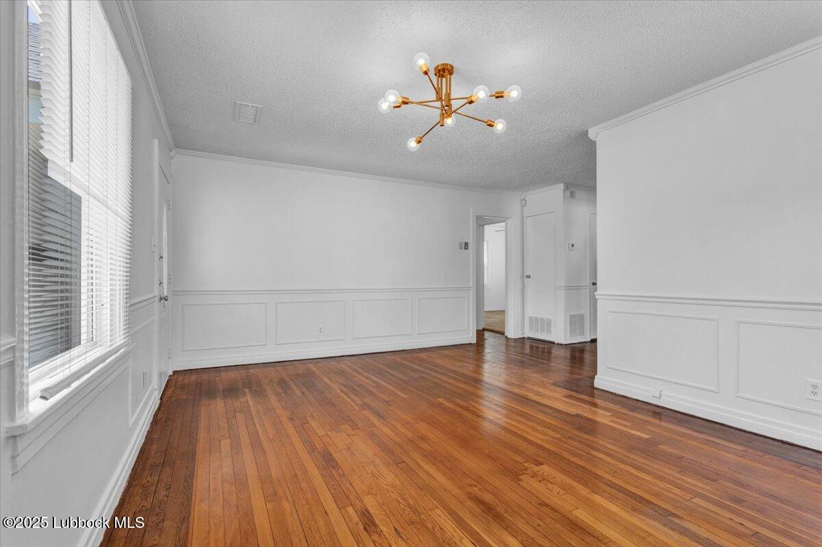 2427 26th Street Lubbock, TX 79411 - Photo 7 of 28 a view of an empty room with wooden floor and a window