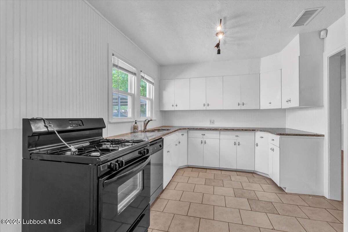 2427 26th Street Lubbock, TX 79411 - Photo 10 of 28 a kitchen with granite countertop a stove sink and cabinets